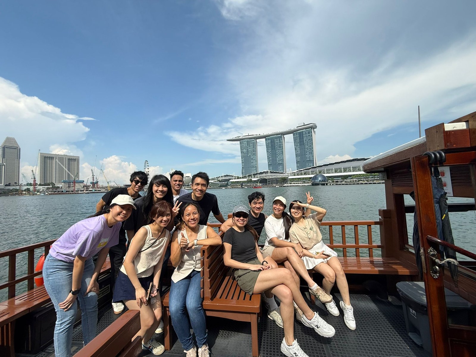Zion Global Marketing team enjoying a boat outing with Marina Bay behind them